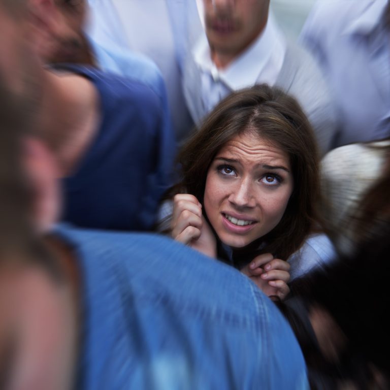 Drowning in people. Shot of a fearful young woman feeling trapped by the crowd